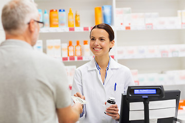 Image showing apothecary selling drug to senior man at pharmacy