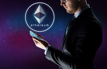 Image showing businessman with smartphone and ethereum hologram