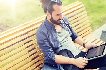 Image showing man with tablet pc sitting on city street bench