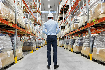 Image showing businessman in helmet at warehouse