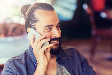 Image showing happy man calling on smartphone at bar or pub