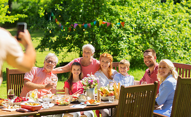 Image showing happy family photographing at dinner in garden