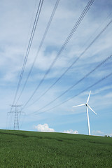 Image showing a windturbine close to a electric pylon