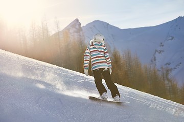 Image showing Female snowboarder in sun flare