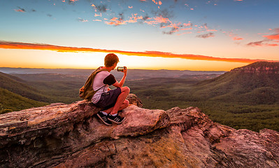 Image showing Male hiker or bushwalker taking photos of the sunset