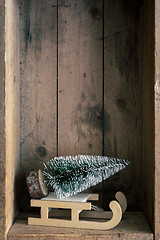 Image showing Christmas decoration sledge and tree in a wooden box background