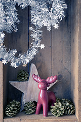 Image showing Christmas decoration deer figure and star in a wooden box backgr