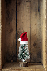 Image showing Christmas decoration Santa Claus hat and tree in a wooden box ba