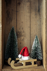 Image showing Christmas decoration sledge with Santa Claus hat and trees in a 