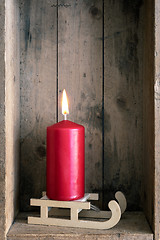 Image showing Christmas decoration red candle on a sledge in a wooden box back