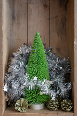Image showing Christmas decoration pinecone and tree in a wooden box backgroun