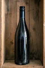 Image showing a dirty bottle of wine in a wooden box