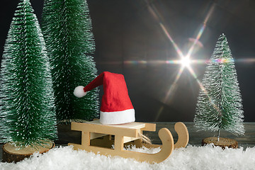 Image showing Christmas decoration with a red Santa Claus hat on a sledge besi