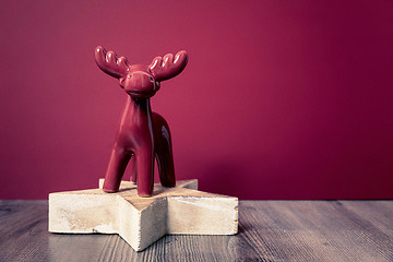 Image showing Christmas decoration wooden star with red deer background