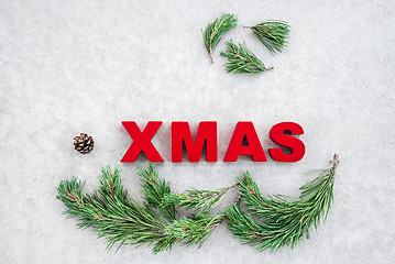 Image showing Pine branches and the word Xmas on gray background