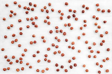 Image showing Peeled hazelnuts on white wooden background