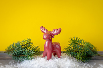 Image showing Christmas decoration red reindeer with twiggs in front of a yell