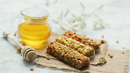 Image showing Delicious cereal bars and honey in jar