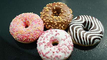 Image showing Delicious glazed doughnuts on glass