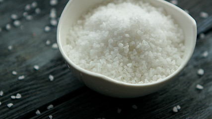 Image showing Bowl of salt on dark desk 