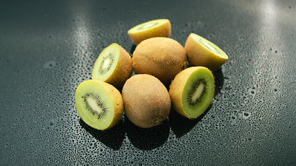 Image showing Whole and cut kiwifruit on table 