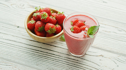 Image showing Glass with smoothie and bowl of strawberries