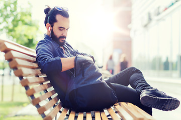 Image showing man with backpack and earphones in city