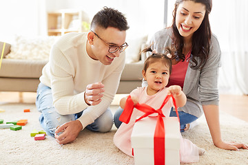 Image showing baby girl with birthday gift and parents at home