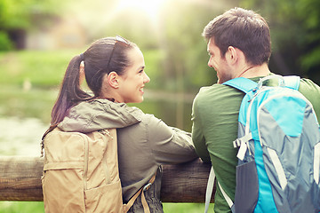 Image showing smiling couple with backpacks in nature