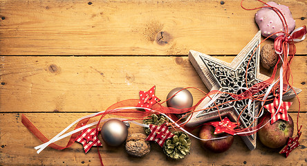 Image showing Christmas decoration red ribbon on a star with wooden background