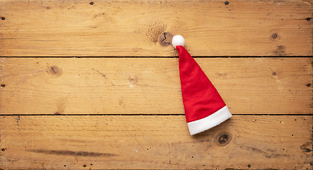 Image showing red Santa Claus hat with wooden background