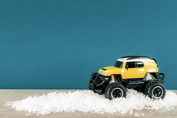 Image showing yellow SUV monster car truck toy in winter snow