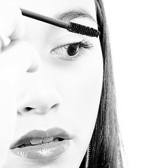 Image showing Young Girl Applying Mascara To Her Eyelashes