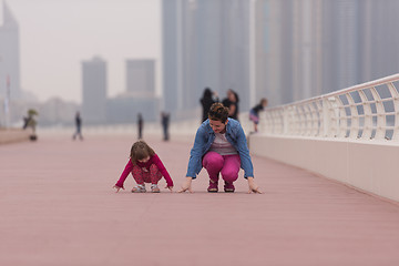 Image showing mother and cute little girl on the promenade