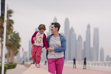 Image showing mother and cute little girl on the promenade