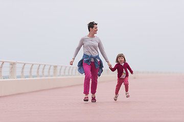 Image showing mother and cute little girl on the promenade by the sea