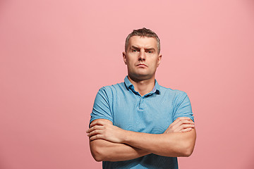 Image showing The serious businessman standing and looking at camera against pink background.