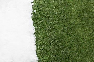 Image showing Meeting snow on green grass close up - between winter and spring concept background