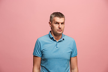 Image showing Suspiciont. Doubtful pensive man with thoughtful expression making choice against pink background