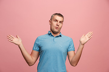 Image showing The young attractive man looking suprised isolated on pink