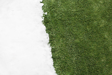 Image showing Meeting snow on green grass close up - between winter and spring concept background