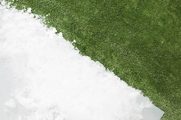 Image showing Meeting snow on green grass close up - between winter and spring concept background