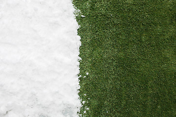 Image showing Meeting snow on green grass close up - between winter and spring concept background