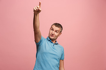 Image showing The young attractive man looking suprised isolated on pink