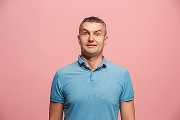 Image showing The young attractive man looking suprised isolated on pink