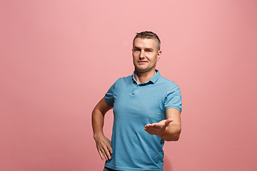 Image showing The young attractive man looking suprised isolated on pink