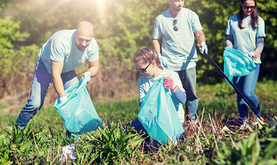 Image showing volunteers with garbage bags cleaning park area