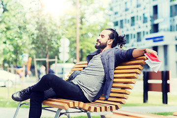 Image showing man with notebook and bag on city street bench