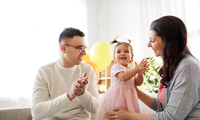 Image showing happy baby girl and parents at home birthday party