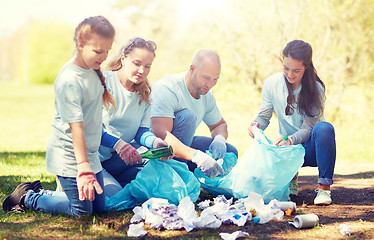 Image showing volunteers with garbage bags cleaning park area